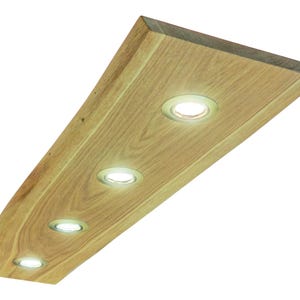 Op de afbeelding: Een rechthoekige lamp gemaakt van een enkel stuk lichtgekleurd natuurlijk hout met een zichtbare houtnerf. De lamp is voorzien van vier ronde, zilverkleurige inbouwspots op een rij die een helder wit licht uitstralen.