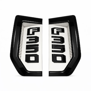 Puede incluir: Dos emblemas F350 en blanco y negro. Los emblemas tienen un borde negro brillante y un interior blanco con el texto F350 en negro. Los emblemas están diseñados para ser instalados en un vehículo.