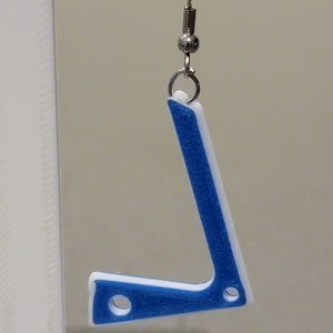 Pu&ograve; includere: Orecchini stampati in 3D blu e bianchi a forma di lettera L. Gli orecchini sono appesi a ganci argentati.