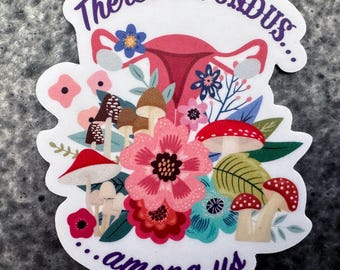 May include: A sticker with a floral design and the text "There's a FUNDUS... among us." The design includes a uterus, mushrooms, and various flowers in shades of pink, red, blue, and green.