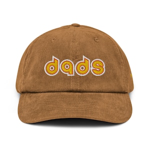 May include: A brown corduroy baseball cap with the word "dads" embroidered in white and yellow letters.
