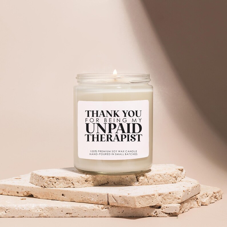 a white candle sitting on top of a pile of rocks