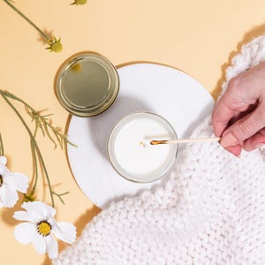 a person holding a spoon over a bowl of milk