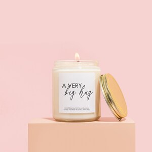 a jar of a candle sitting on top of a pink block