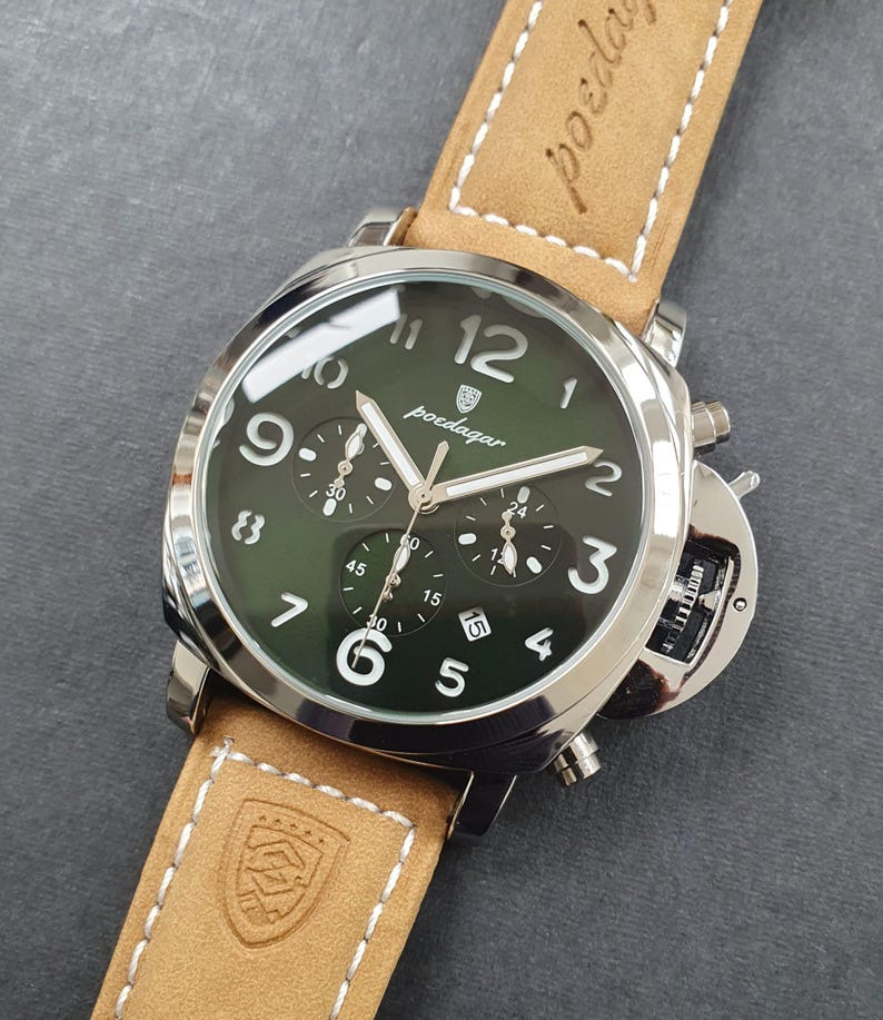 May include: A silver and green chronograph wristwatch with a brown leather band. The watch face has white numbers and hands, and the brand name "poedagar" is printed in white.