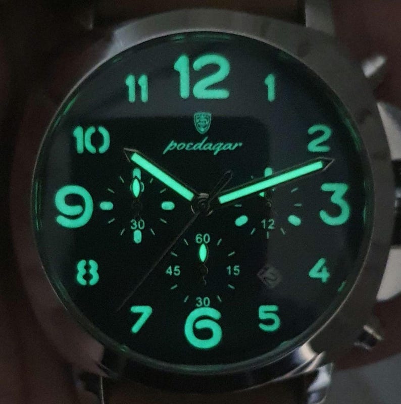 May include: A black chronograph watch with luminous green hands and numbers. The watch face has the brand name "poedagar" printed on it.