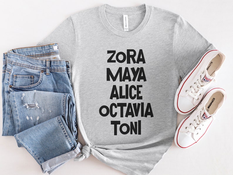 May include: A gray t-shirt with the names Zora, Maya, Alice, Octavia, and Toni printed in black letters.