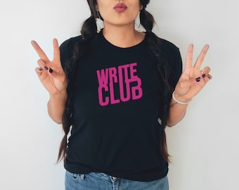 Może przedstawiać: Czarny t-shirt z napisem "WRITE CLUB" w różowych literach.