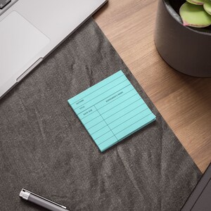 May include: A light blue lined notepad with the words "Author", "Title", "Date Due", and "Borrower's Name" printed on it.