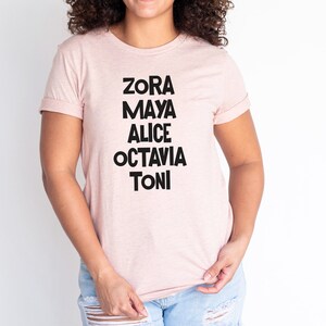 May include: A pink t-shirt with black text that reads "Zora Maya Alice Octavia Toni".