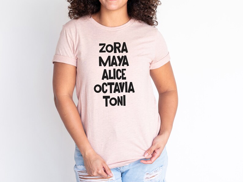 May include: A pink t-shirt with black text that reads "Zora Maya Alice Octavia Toni".
