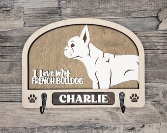 May include: Wooden key holder with a white silhouette of a French Bulldog. The text "I love my French Bulldog" and the name "CHARLIE" are on the holder. There are two hooks on the bottom.