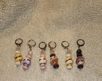 Puede incluir: Seis llaveros hechos a mano con cuentas decorativas en varios colores, incluyendo blanco, amarillo, rosa, morado y marrón. Cada llavero tiene un anillo de metal y un diseño de cuentas único.