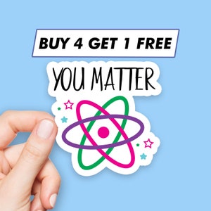 Op de afbeelding: Een witte sticker met een roze, groene en paarse atoomontwerp. De sticker zegt "You Matter" en heeft een klein sterontwerp rond het atoom. De sticker heeft ook een banner bovenaan die zegt "Buy 4 Get 1 Free".