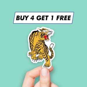 Puede incluir: Una pegatina con un tigre amarillo y negro con la boca roja y dientes blancos. El tigre está en posición de cuclillas con las garras extendidas. La pegatina tiene el texto "BUY 4 GET 1 FREE" en la parte superior.