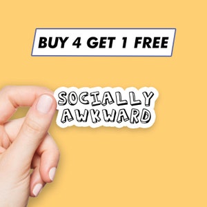 May include: A white sticker with black text that reads "Socially Awkward" in a bold, outlined font. The sticker is being held by a hand against a yellow background. A blue banner above the sticker reads "Buy 4 Get 1 Free".