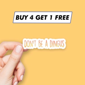 May include: A white sticker with the text "DON'T BE A DINGUS" in orange and yellow gradient lettering. The sticker is being held by a hand against a yellow background. A blue banner above the sticker reads "BUY 4 GET 1 FREE".