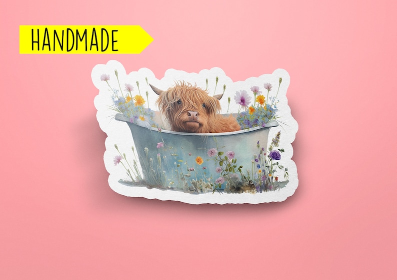 May include: A handmade sticker featuring a Highland cow taking a bath in a blue tub surrounded by colorful wildflowers.