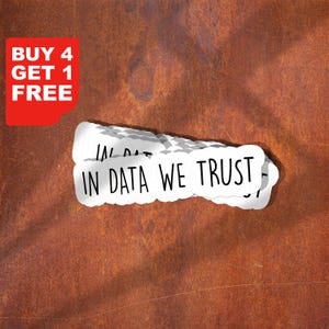 Può includere: Adesivi bianchi con la scritta "IN DATA WE TRUST" in grassetto. Un angolo rosso mostra "BUY 4 GET 1 FREE". Gli adesivi sono su una superficie marrone ruggine e strutturata.