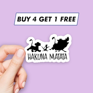 May include: White sticker with black silhouettes of Simba, Timon, and Pumbaa running. The text "Hakuna Matata" is below the silhouettes. The sticker has a blue banner at the top that says "Buy 4 Get 1 Free".