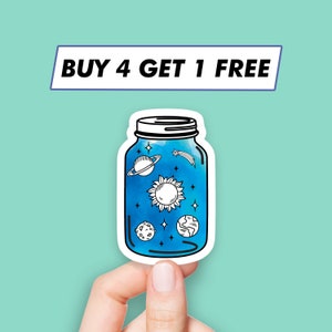 May include: A blue glass jar sticker with a white outline. The jar contains a watercolor-style depiction of the sun, planets, and stars. The sticker has the text "BUY 4 GET 1 FREE" at the top.