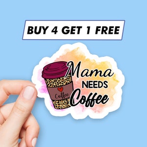 Puede incluir: Una pegatina de estilo acuarela con una taza de café y el texto "Mama Needs Coffee". La taza de café es marrón con un diseño de estampado de leopardo y un corazón rojo con la palabra "Coffee" en ella. La pegatina tiene un borde blanco.