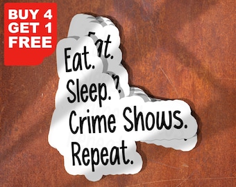 May include: A set of five white stickers with black text that reads "Eat. Sleep. Crime Shows. Repeat." The stickers are stacked on top of each other and are slightly angled. The background is a rusty brown surface.