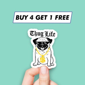 Puede incluir: Una pegatina en blanco y negro de un pug con gafas de sol y una cadena de oro con un colgante de signo de dólar. La pegatina dice "Thug Life" en texto negro.
