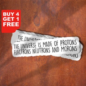 以下が含まれることがあります： 「THE UNIVERSE IS MADE OF PROTONS ELECTRONS NEUTRONS AND MORONS」というテキストが書かれた白いステッカーが部分的に見えます。 「BUY 4 GET 1 FREE」というテキストが入った赤いコーナーが左上にあります。 背景は錆びた茶色です。