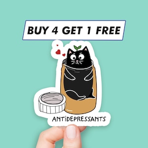 May include: A sticker with a black cat inside a jar labeled "ANTIDEPRESSANTS". The cat has a green sprout growing from its head and is surrounded by three red hearts. The sticker also includes the text "BUY 4 GET 1 FREE".