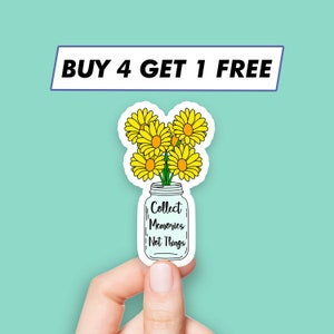 Pode incluir: Um adesivo com um frasco de vidro cheio de margaridas amarelas e o texto "Collect Memories Not Things".