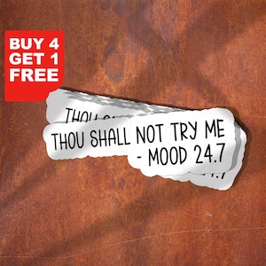 May include: White sticker with the text "THOU SHALL NOT TRY ME - MOOD 24.7" in black. A red rectangle in the upper left corner reads "BUY 4 GET 1 FREE" in white. The background is a textured, rusty brown.