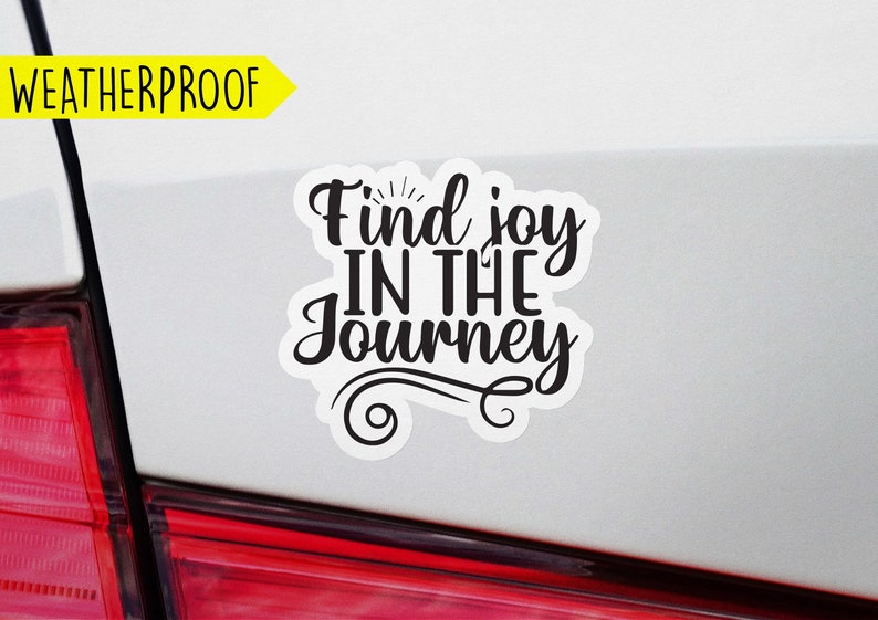 May include: White car with a black vinyl sticker that says "Find joy in the journey".