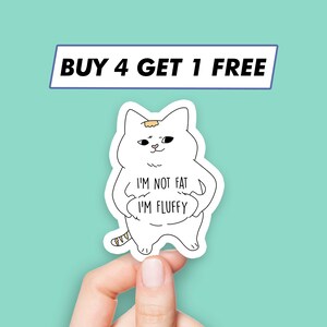 May include: White cat sticker with a cute expression, holding a sign that says "I'm not fat I'm fluffy".