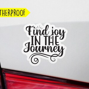 May include: Weatherproof car sticker with the text "Find joy in the journey" in black lettering with a decorative swirl design.