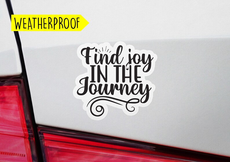 May include: Weatherproof car sticker with the text "Find joy in the journey" in black lettering with a decorative swirl design.