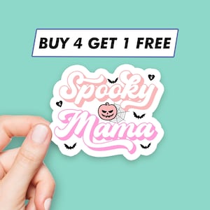 May include: Pink and white sticker with the text "Spooky Mama" in a retro font. The sticker features a small orange pumpkin with a black face and a spiderweb. There are also small black bats and hearts around the text.