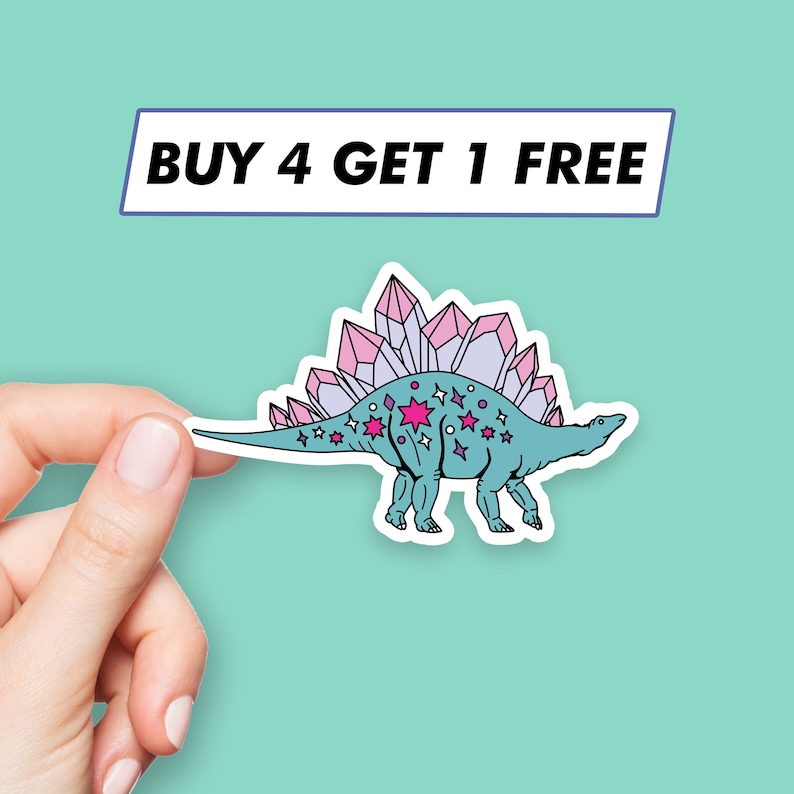 May include: A sticker featuring a blue dinosaur with pink crystals on its back and pink stars on its body. The sticker has a white outline and the text "BUY 4 GET 1 FREE" is printed on a blue rectangle above the dinosaur.