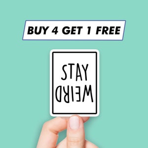 Peut inclure: Un autocollant blanc avec une bordure noire et le texte "STAY WEIRD" en lettres noires.