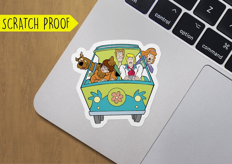 K&ouml;nnte beinhalten: Ein Aufkleber mit dem Mystery Machine aus Scooby-Doo. Der Van ist gr&uuml;n und blau mit einer gelben Blume vorne. Die Figuren Scooby-Doo, Shaggy, Fred, Daphne und Velma sind im Van.