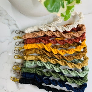 May include: A set of 10 twisted cord keychains in various colors, including white, brown, orange, yellow, green, and blue. Each keychain has a gold-colored metal clasp.