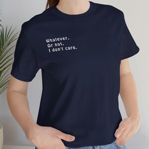 May include: A navy blue short-sleeved t-shirt featuring white text on the upper left chest that reads: Whatever. Or not. I don't care. The garment has a classic crew neckline and a simple, solid-coloured design throughout the fabric.