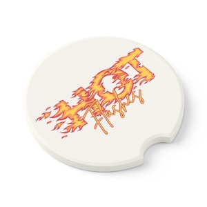 May include: A white car coaster with a curved edge and a cutout for easy removal. The coaster features the word "Flashes" in orange script, with a stylized flame design in orange and yellow.