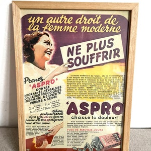 Puede incluir: Un anuncio vintage para las pastillas para el dolor Aspro que presenta a una mujer sosteniendo un cartel que dice "NE PLUS SOUFFRIR" (No más sufrimiento). El anuncio está en francés y promociona Aspro como una solución moderna para los dolores de cabeza, las migrañas y otras dolencias. El anuncio también incluye una lista de precios para diferentes tamaños de Aspro.