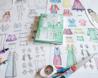 Peut inclure: Un ensemble de poupées en papier avec différentes tenues et accessoires. Les poupées sont imprimées sur du papier blanc et sont prêtes à être colorées. L'ensemble comprend une paire de ciseaux et des crayons de couleur. Le texte "Color your way!" est écrit en haut de la page.
