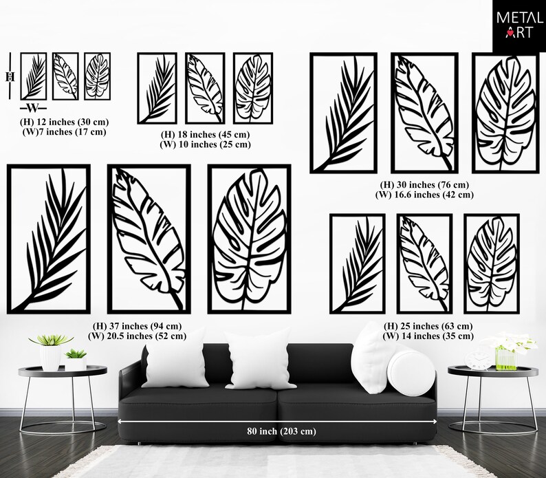 May include: Black metal wall art featuring stylized leaf designs in rectangular frames. The image shows various sizes, including a set of three 12-inch (30 cm) high panels and a large 37-inch (94 cm) high panel. The art is displayed above a black sofa.