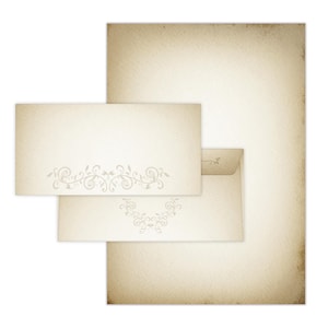 Peut inclure: Ensemble de papeterie de style vintage comprenant une grande feuille de papier, une enveloppe et une carte. Le papier et la carte présentent un motif floral décoratif. L'ensemble est de couleur crème et vieilli.