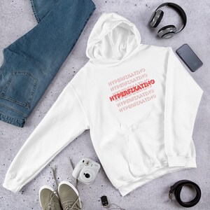 May include: White hoodie with the text "HYPERFIXATING" repeated in red, with the word "HYPERFIXATING" in bold red letters.