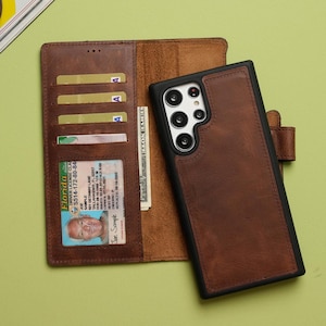 May include: A brown leather wallet-style phone case with a black frame. The interior features multiple card slots, a clear ID window containing a Florida driver license, and a side pocket holding a US dollar bill. The case has a magnetic closure.