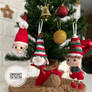 May include: Crochet PDF pattern for three Christmas ornaments: a Santa Claus, a gnome, and an elf. The ornaments are red, green, and white with striped hats and are hanging on a Christmas tree.